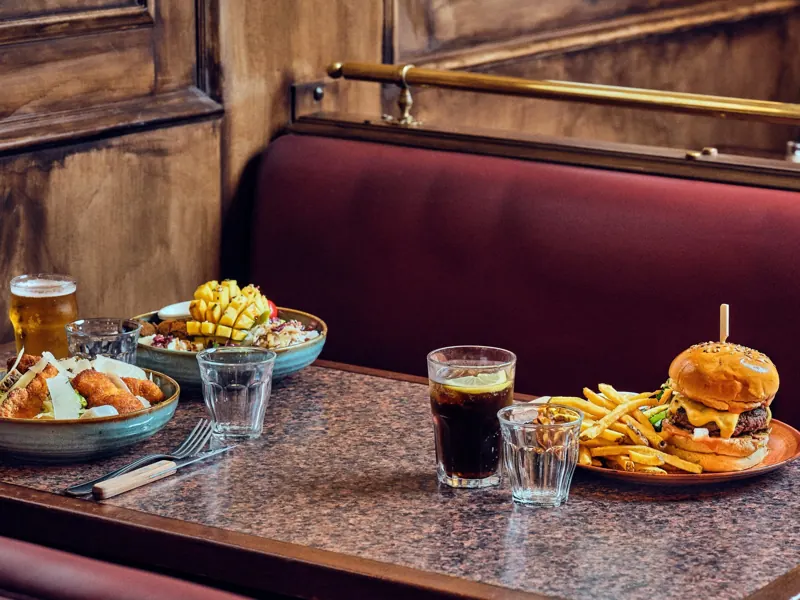Burger frites et poke bowl sur une banquette de la brasserie Batistou